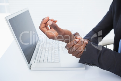 Businessman holding his sore wrist from typing