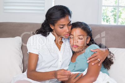 Concerned mother taking her daughters temperature