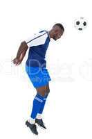 Football player in blue heading ball