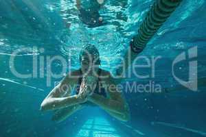 Athletic swimmer swimming towards camera