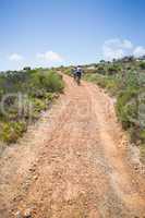 Fit couple cycling up mountain trail