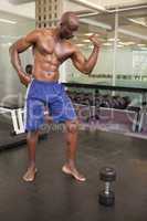 Muscular man flexing muscles in gym