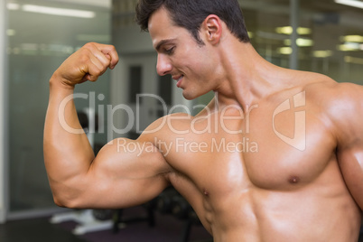 Muscular man flexing muscles in gym