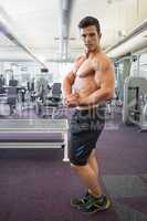 Shirtless muscular man posing in gym