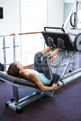 Fit brunette using weights machine for legs