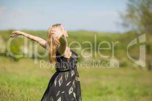 Pretty blonde in sundress standing with arms out