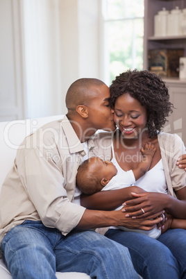 Happy parents spending time with baby on the couch