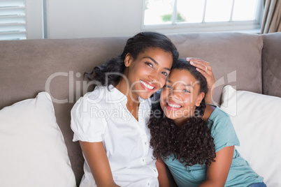 Happy mother and daughter together on sofa