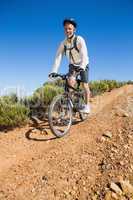 Fit cyclist cycling on country terrain