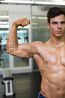 Muscular man flexing muscles in gym