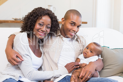 Happy parents spending time with baby on the couch