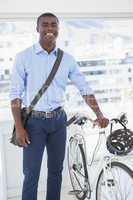 Happy businessman standing with his bike