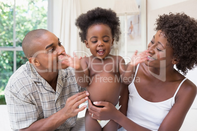 Happy couple on bed with baby daughter