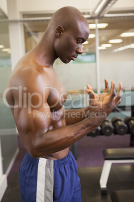 Serious shirtless muscular man in gym