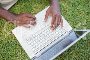 Man relaxing in his garden using laptop