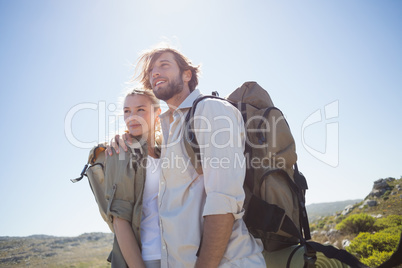 Hiking couple standing on mountain terrain smiling