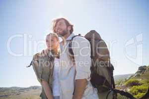 Hiking couple standing on mountain terrain smiling