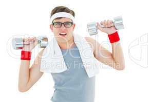 Geeky hipster lifting heavy dumbbells