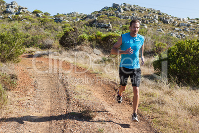 Athletic man jogging on country trail