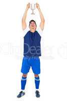 Football player in blue holding winners cup