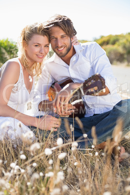 Handsome man serenading his girlfriend with guitar