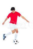 Football player in red kicking ball