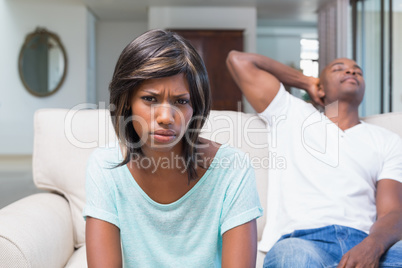 Unhappy couple not talking after argument on sofa