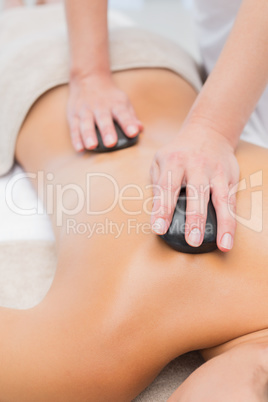 Beautiful woman receiving stone massage at spa center