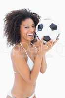 Athletic girl in white bikini holding football