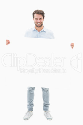 Attractive young man smiling and holding poster