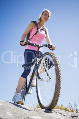 Fit pretty cyclist on a rocky terrain