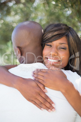 Happy couple hugging each other in garden