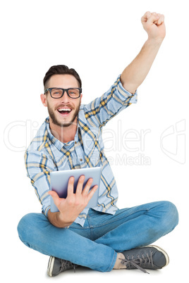 Handsome hipster using tablet pc and cheering