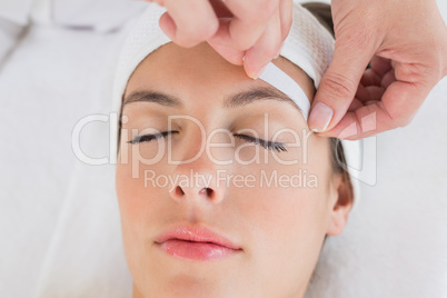 Hand waxing beautiful womans eyebrow