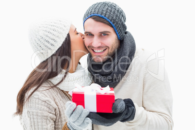 Attractive young couple in warm clothes holding gift