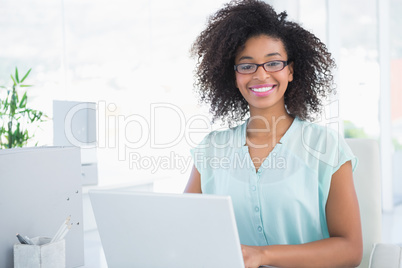 Happy hipster businesswoman working on laptop