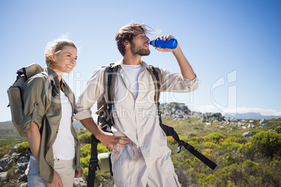 Hiking couple standing on mountain terrain taking a break