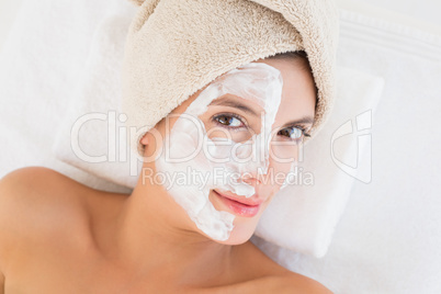 Attractive having white cream on her face at spa center