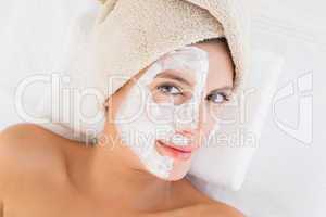 Attractive having white cream on her face at spa center