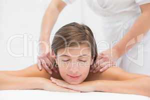 Attractive woman receiving shoulder massage at spa center