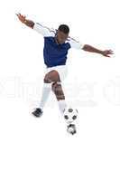 Football player in blue jersey controlling ball