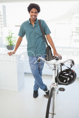 Handsome businessman standing with his bike