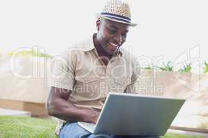 Handsome man relaxing in his garden using laptop