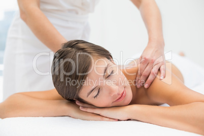 Attractive woman receiving shoulder massage at spa center