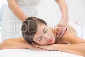 Attractive woman receiving shoulder massage at spa center