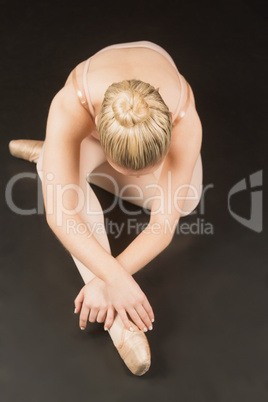 Ballerina sitting and bending forward