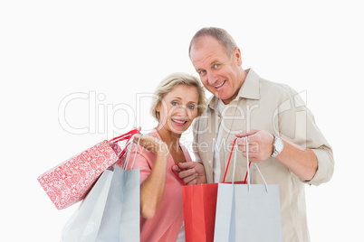 Smiling mature couple holding shopping bags