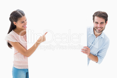 Attractive young couple smiling and holding poster