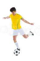 Football player in yellow jersey kicking ball