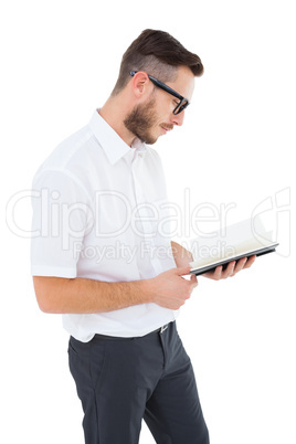 Geeky young man reading from black book